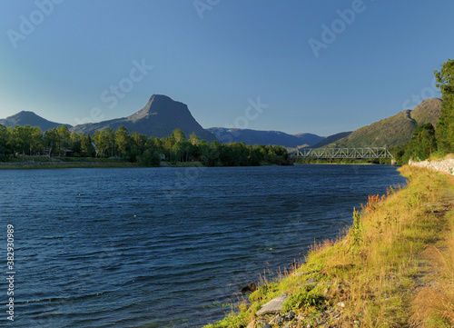 View To The River Reisaelva And The Mountains Near Sorkjosen On A Sunny Summer Day With A Clear Blue Sky