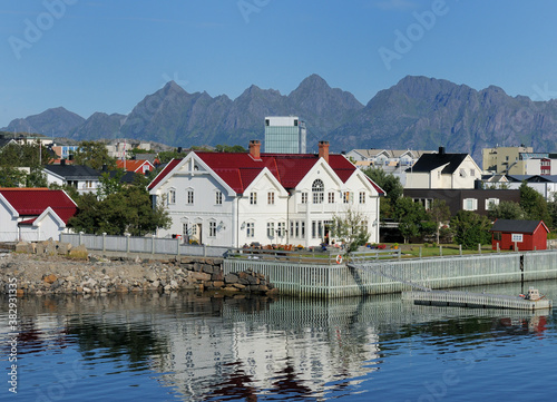 Waterfront Of Svolvaer Reflecting In The Water On Lofoten Island Austvagoy On A Sunny Summer Day With A Clear Blue Sky