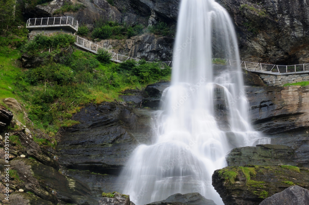 Long Time Exposure Of Steindalsfossen Falls In The Fosselva River In Norway On A Sunny Summer Day With A Clear Blue Sky And A Few Clouds