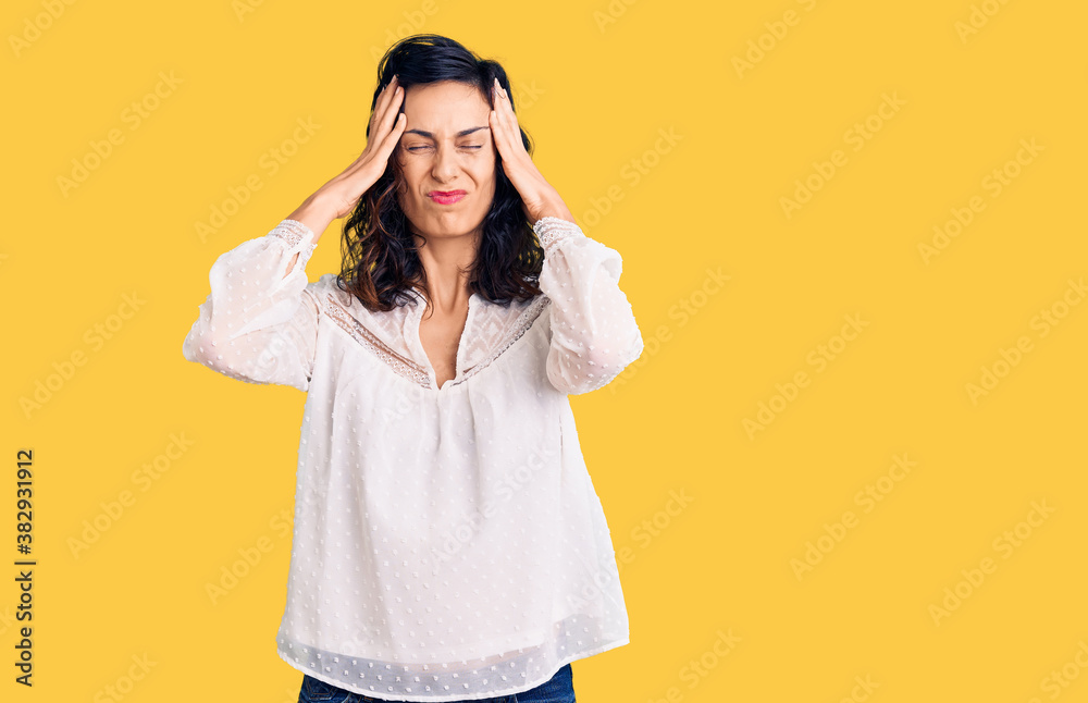Young beautiful hispanic woman wearing casual clothes suffering from headache desperate and stressed because pain and migraine. hands on head. Young beautiful hispanic woman wearing casual clothes suffering from headache desperate and stressed because pain and migraine. hands on head.