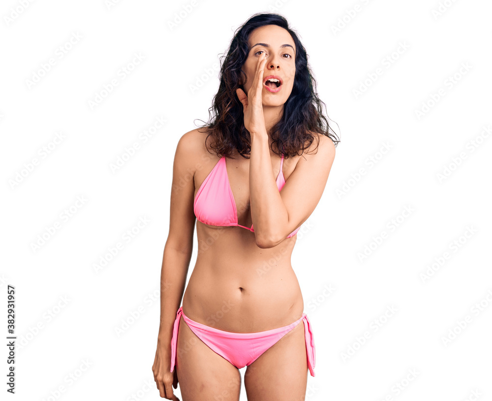 Young beautiful hispanic woman wearing bikini hand on mouth telling secret rumor, whispering malicious talk conversation Young beautiful hispanic woman wearing bikini hand on mouth telling secret rumor, whispering malicious talk conversation