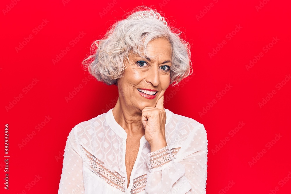 Senior grey-haired woman wearing casual clothes smiling looking confident at the camera with crossed arms and hand on chin. thinking positive.