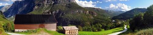 Panorama View To An Ancient Wooden Barn And Stalheim In The Spectacular Mountains Of The Naeroydalen Valley On A Sunny Summer Day With A Clear Blue Sky And A Few Clouds photo