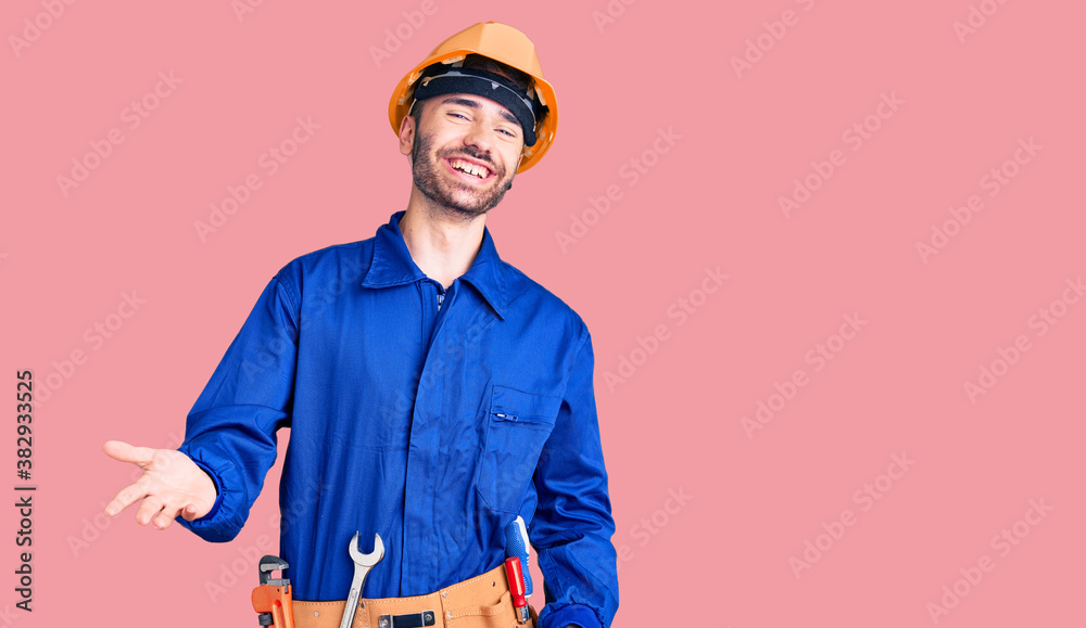 Young hispanic man wearing worker uniform smiling cheerful with open arms as friendly welcome, positive and confident greetings Young hispanic man wearing worker uniform smiling cheerful with open arms as friendly welcome, positive and confident greetings