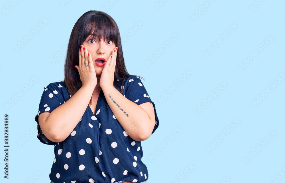Young plus size woman wearing casual clothes afraid and shocked, surprise and amazed expression with hands on face Young plus size woman wearing casual clothes afraid and shocked, surprise and amazed expression with hands on face