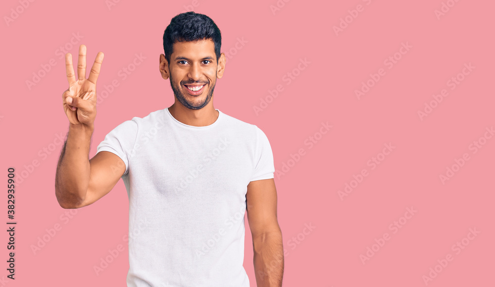 Young latin man wearing casual clothes showing and pointing up with fingers number three while smiling confident and happy. Young latin man wearing casual clothes showing and pointing up with fingers number three while smiling confident and happy.