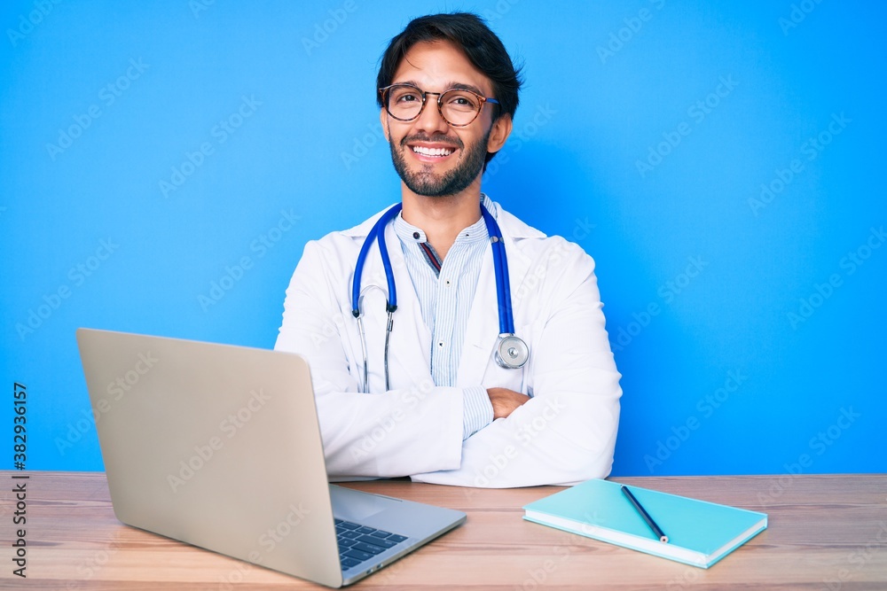 Handsome hispanic man wearing doctor uniform working at the clinic happy face smiling with crossed arms looking at the camera. positive person. Handsome hispanic man wearing doctor uniform working at the clinic happy face smiling with crossed arms looking at the camera. positive person.