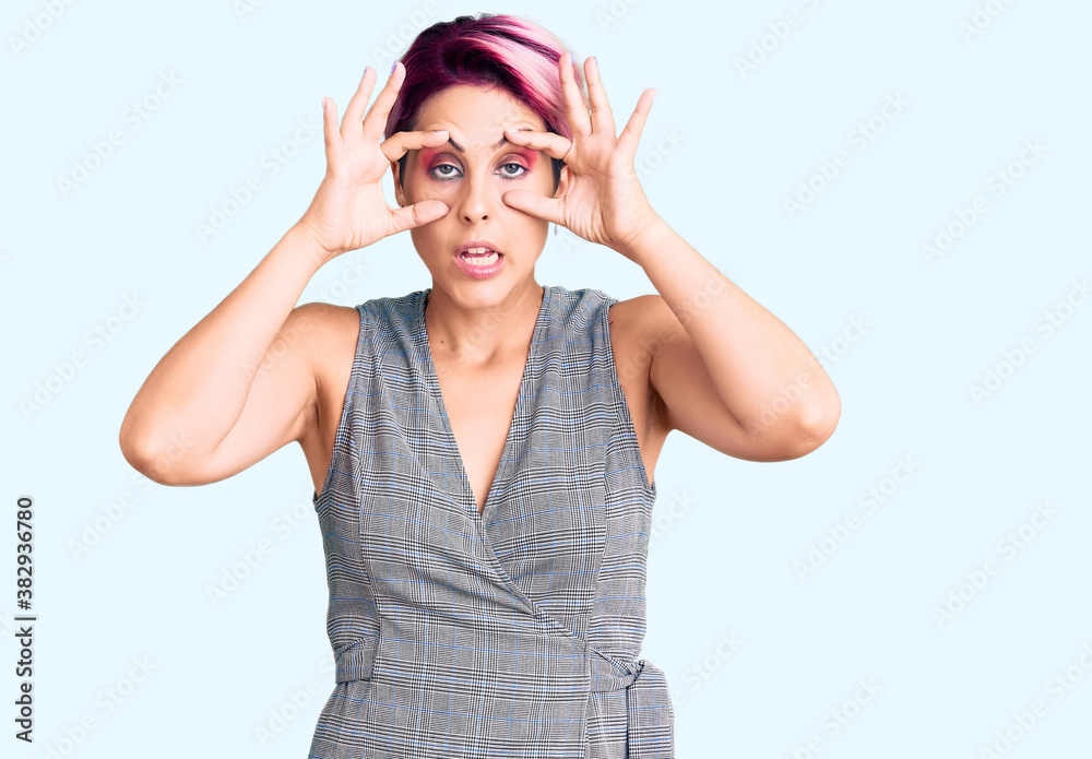 Young beautiful woman with pink hair wearing casual clothes trying to open eyes with fingers, sleepy and tired for morning fatigue Young beautiful woman with pink hair wearing casual clothes trying to open eyes with fingers, sleepy and tired for morning fatigue