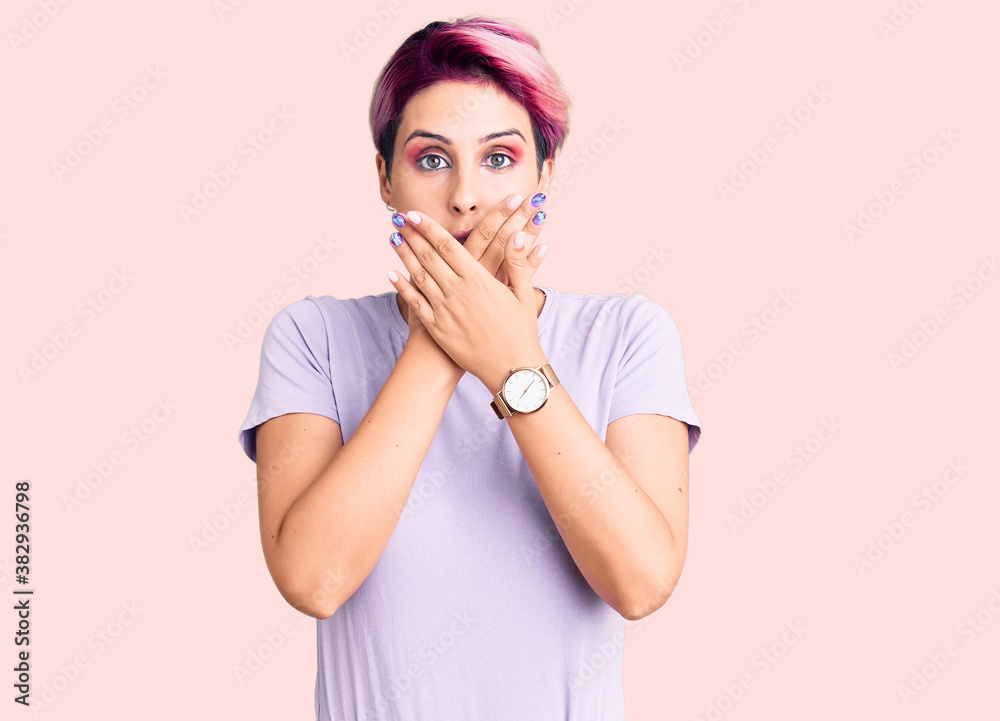 Young beautiful woman with pink hair wearing casual clothes shocked covering mouth with hands for mistake. secret concept.