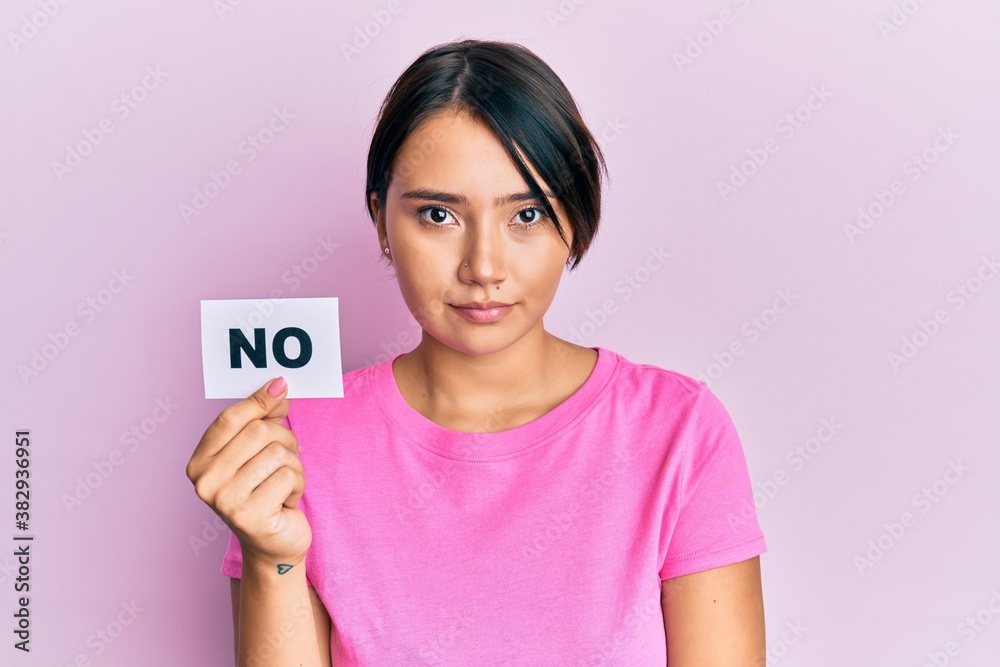 Beautiful young woman with short hair holding no word message thinking attitude and sober expression looking self confident Beautiful young woman with short hair holding no word message thinking attitude and sober expression looking self confident