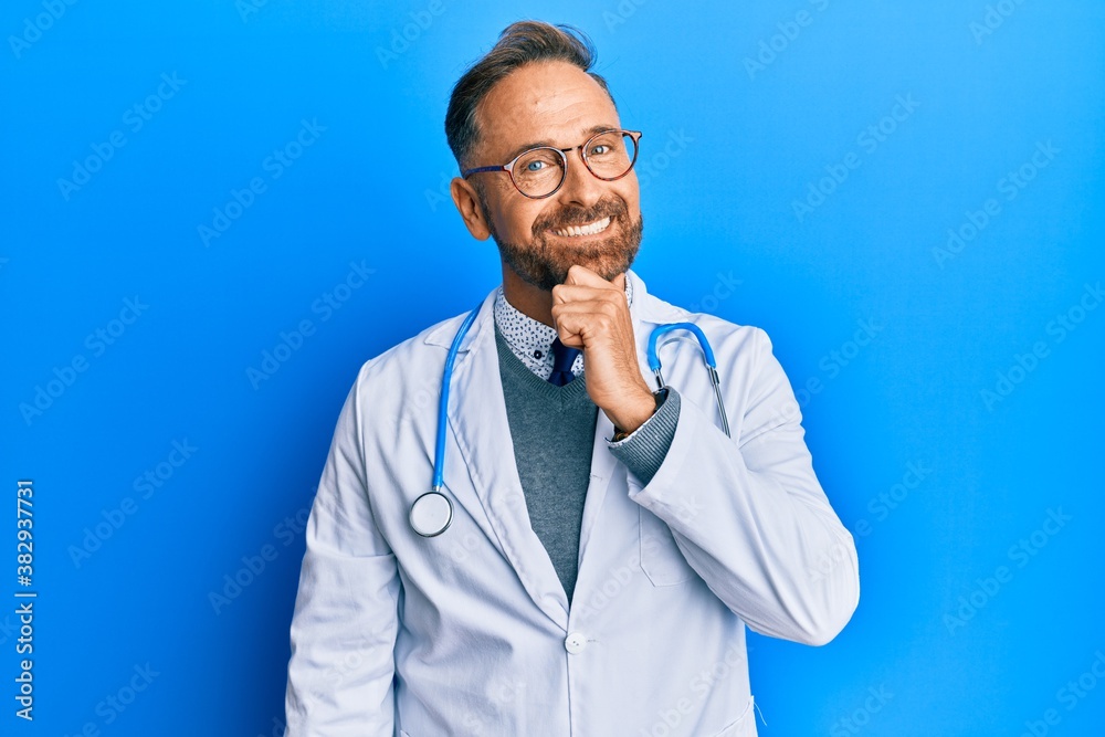 Handsome middle age man wearing doctor uniform and stethoscope looking confident at the camera with smile with crossed arms and hand raised on chin. thinking positive. Handsome middle age man wearing doctor uniform and stethoscope looking confident at the camera with smile with crossed arms and hand raised on chin. thinking positive.
