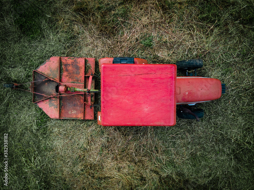 Aerial, bird's eye shot of a red tractor on a field  photo