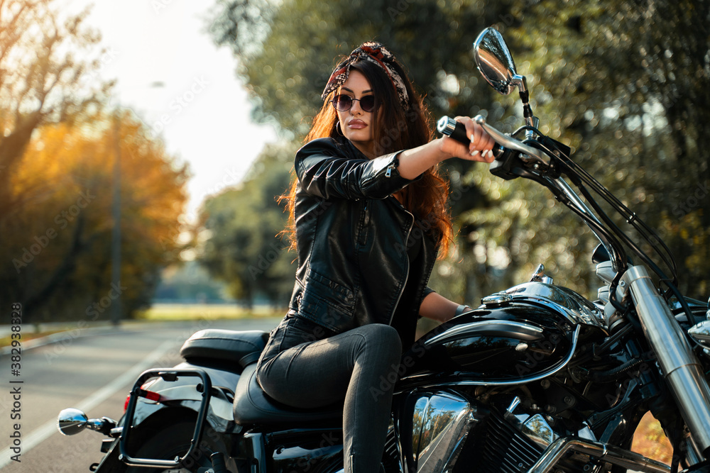 Attractive curly hair girl with bandana on motorbike one the road, posing.  foto de Stock | Adobe Stock
