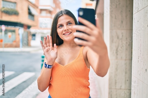 Young middle east girl smiling happy doing video call using smartphone at the city.