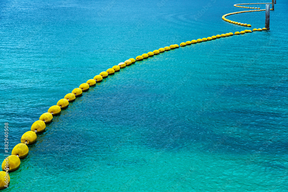 Yellow curves of buoys in clear blue sea