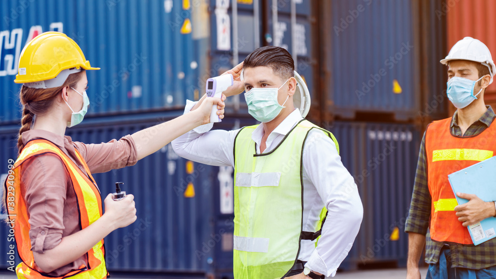 Safety of engineer team or construction Have a hard hat, Body temperature monitor to healthy work and mask in factory or container. Prevent accident work or dust and Coronavirus. Concept New Normal Safety of engineer team or construction Have a hard hat, Body temperature monitor to healthy work and mask in factory or container. Prevent accident work or dust and Coronavirus. Concept New Normal