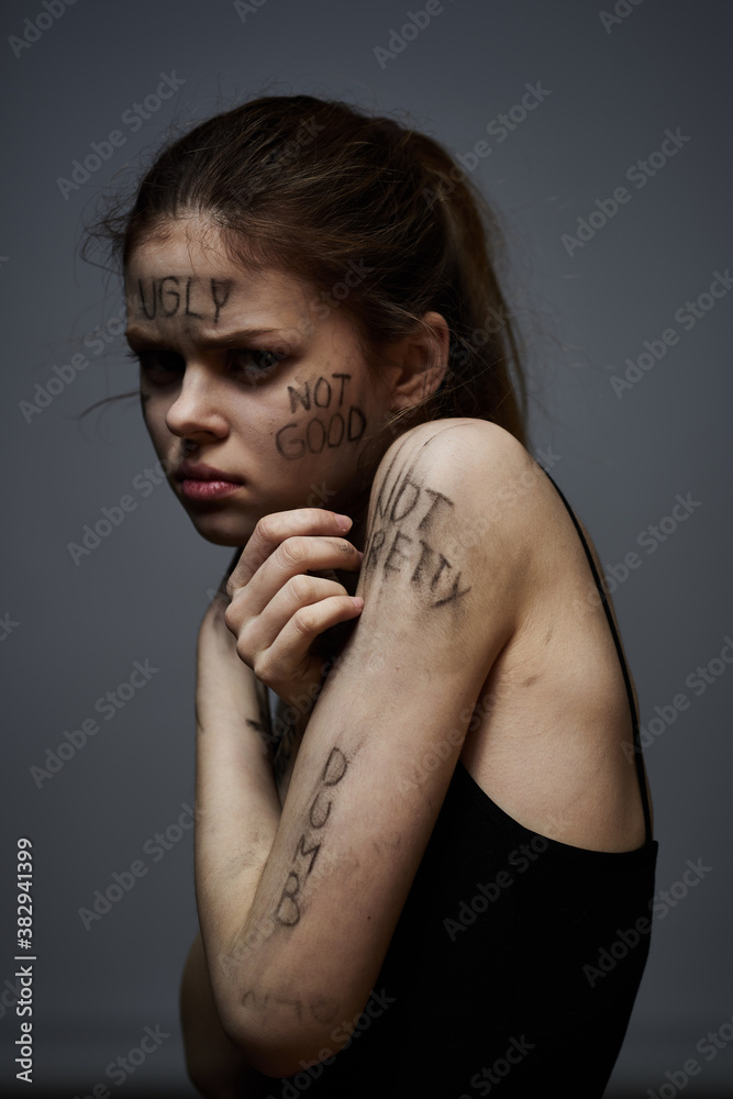 upset woman with offensive writing on her body on gray background touching herself with hands cropped view upset woman with offensive writing on her body on gray background touching herself with hands cropped view