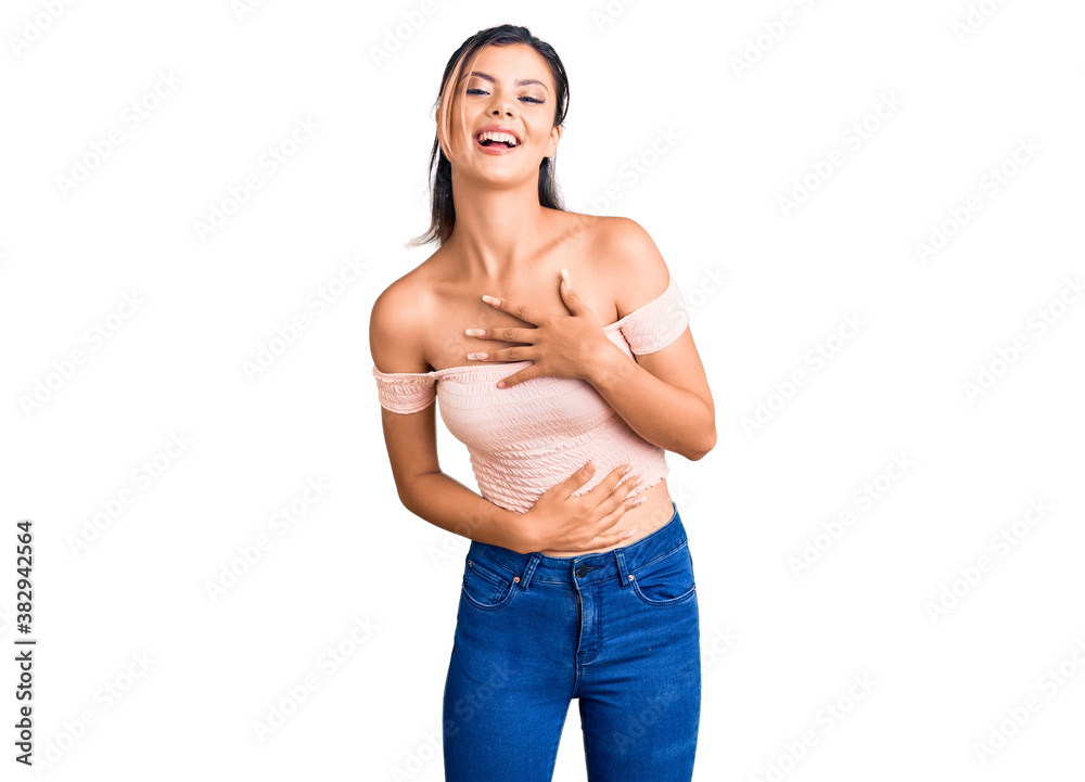 Obraz premium Young beautiful woman wearing casual clothes smiling and laughing hard out loud because funny crazy joke with hands on body.