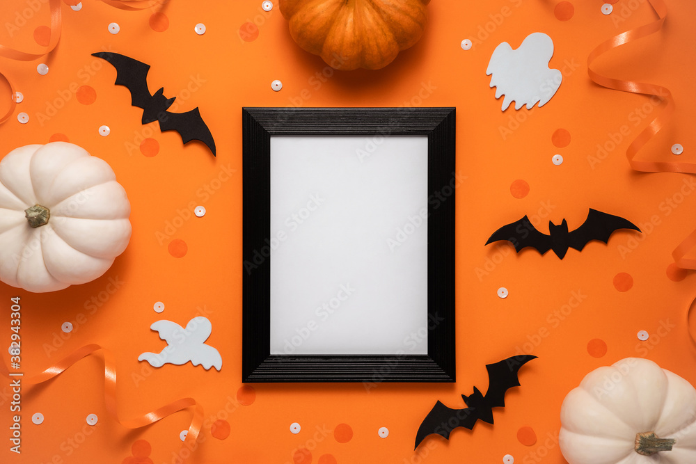 Creative halloween flat lay composition: black frame, bats, pumpkins, confetti and ghost on orange background with place for text, top view. - obrazy, fototapety, plakaty 