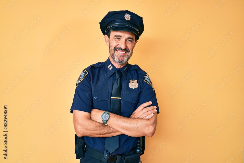 Middle age hispanic man wearing police uniform happy face smiling with crossed arms looking at the camera. positive person. Middle age hispanic man wearing police uniform happy face smiling with crossed arms looking at the camera. positive person.