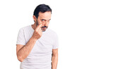 Middle age handsome man wearing casual t-shirt pointing to the eye watching you gesture, suspicious expression