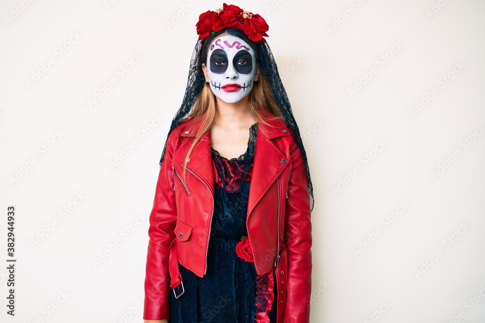Woman wearing day of the dead costume over white relaxed with serious expression on face. simple and natural looking at the camera. Woman wearing day of the dead costume over white relaxed with serious expression on face. simple and natural looking at the camera.