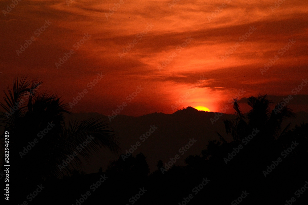 Beautiful sunset with the silhouette of coconut trees