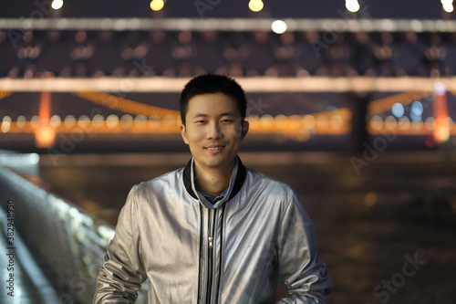 Photography medium shot of one young Asian man looking at camera at night