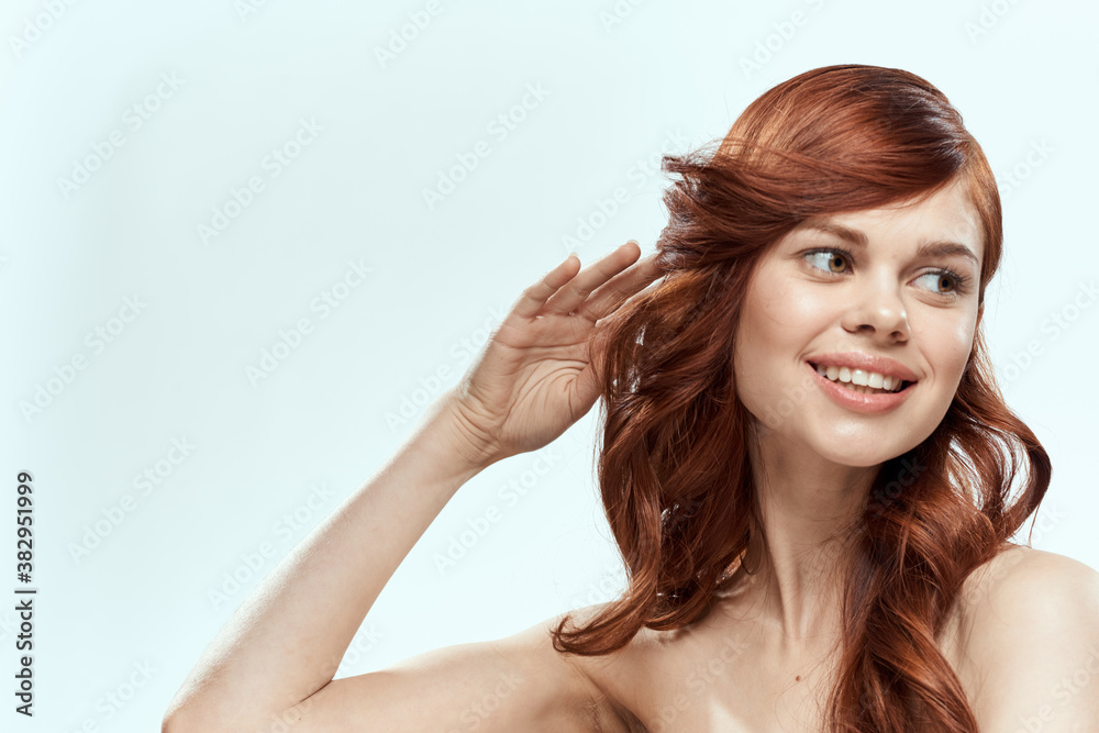 Pretty woman holding hair smile cosmetics lifestyle naked shoulders hairstyle care charm light background Pretty woman holding hair smile cosmetics lifestyle naked shoulders hairstyle care charm light background