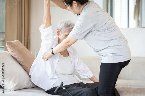 Cuadro en lienzo Assisting in dressing,asian female caregiver taking care of helping elderly pati