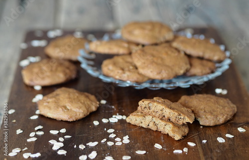 Homemade oatmeal cookies with whole grain rye flour in a glass plate on a wooden background. Diet healthy food.