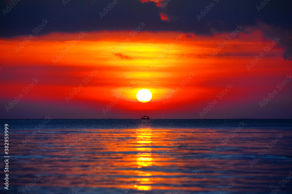 Beautiful golden sunset landscape, orange sky, yellow sun glow, red reflection on water, purple clouds, blue sea, boat silhouette, sunset heat on ocean beach, scenery seascape, Thailand, Samui island