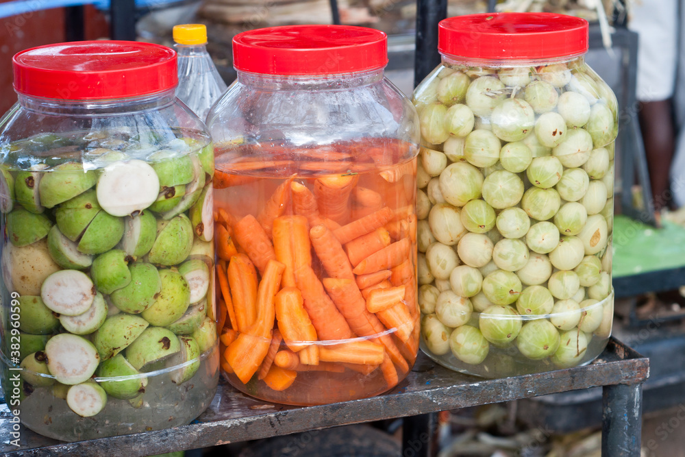 Pickled food in brine gooseberry and carrot stacked in salt water