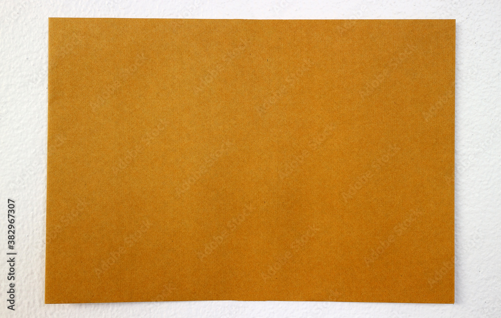 Fototapeta premium Yellow paper on white wall
