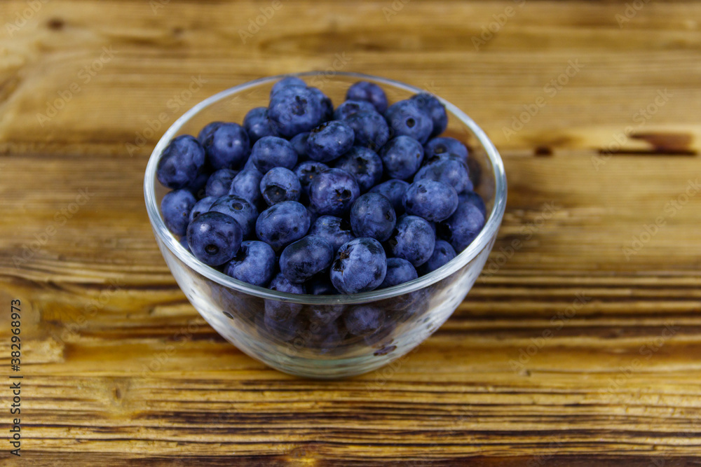 Fresh blueberry in glass bowl on a wooden table Fresh blueberry in glass bowl on a wooden table