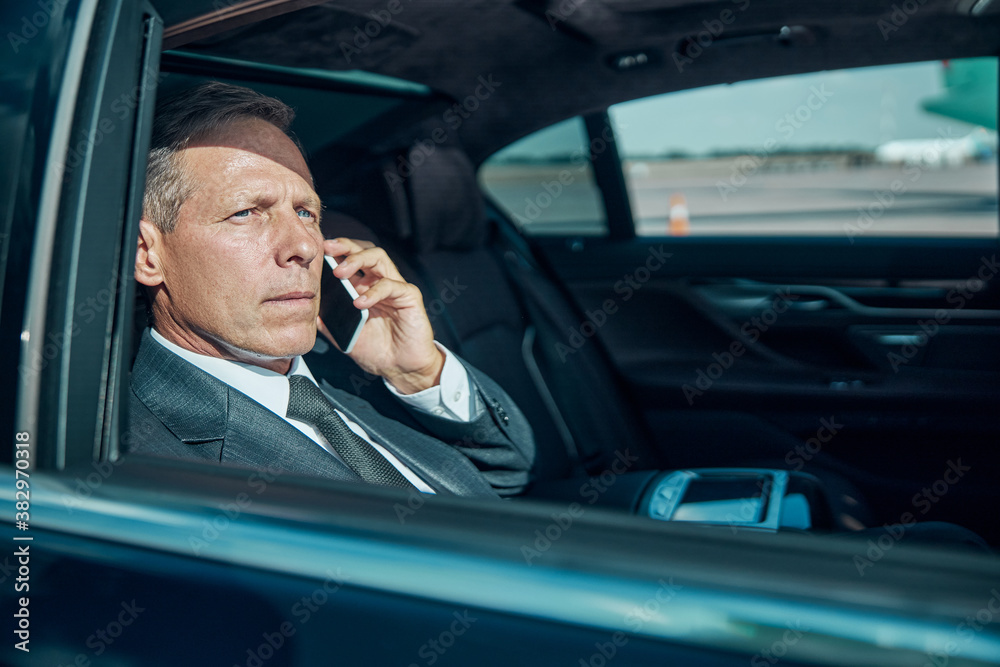 Businessman talking on cell phone in luxury automobile Businessman talking on cell phone in luxury automobile