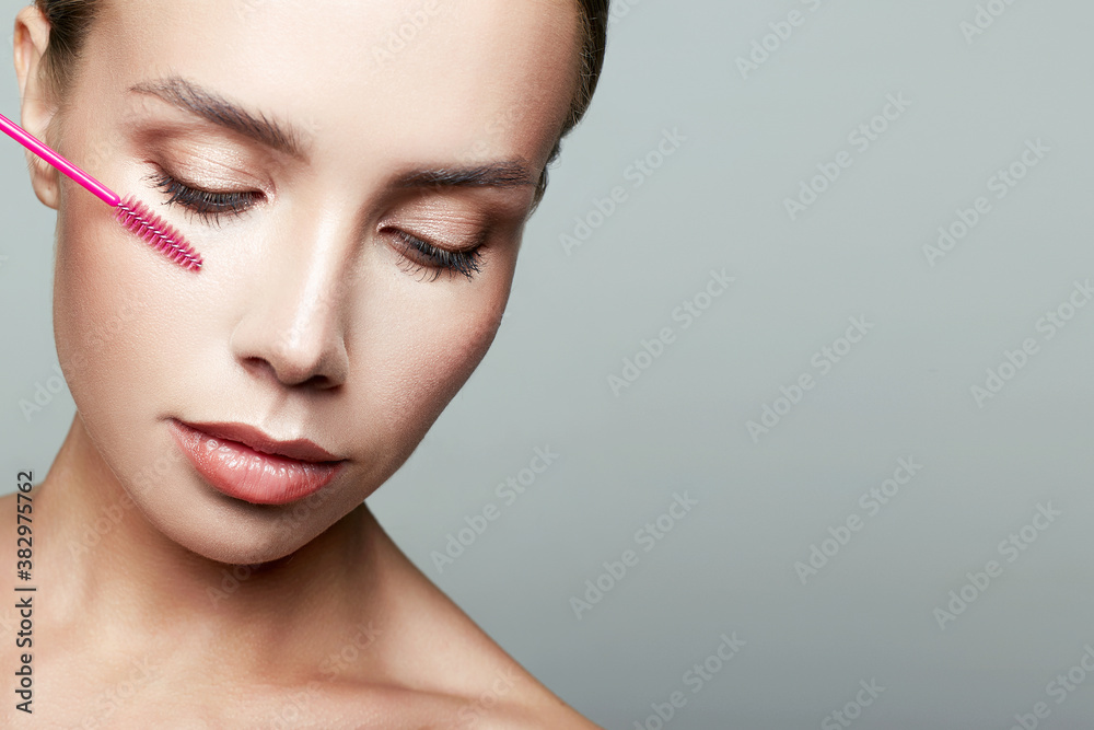 beautiful woman doing make-up, applies mascara beautiful woman doing make-up, applies mascara