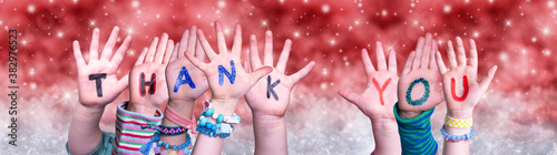 Children Hands Building Colorful English Word Thank You. Red Snowy Christmas Winter Background With Snowflakes And Sparkling Lights