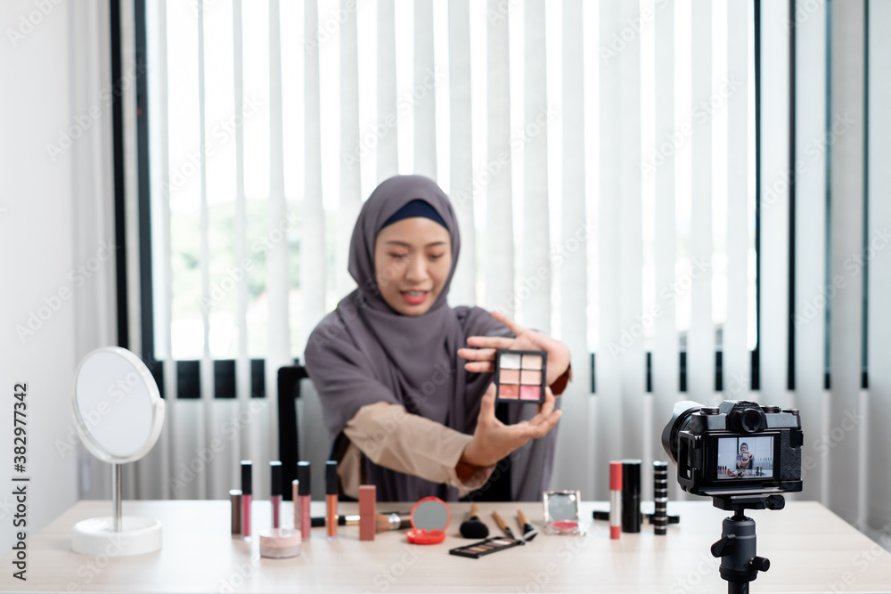 Muslim women making video beauty vlogger bloggers doing a cosmetic makeup tutorial vlog with brushes looking camera Save clips and share them on social media live via the internet Online Muslim women making video beauty vlogger bloggers doing a cosmetic makeup tutorial vlog with brushes looking camera Save clips and share them on social media live via the internet Online