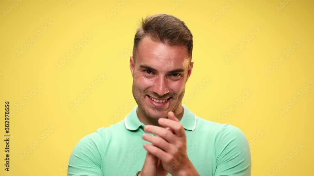 casual attractive man applauding and pointing at the camera on yellow background casual attractive man applauding and pointing at the camera on yellow background