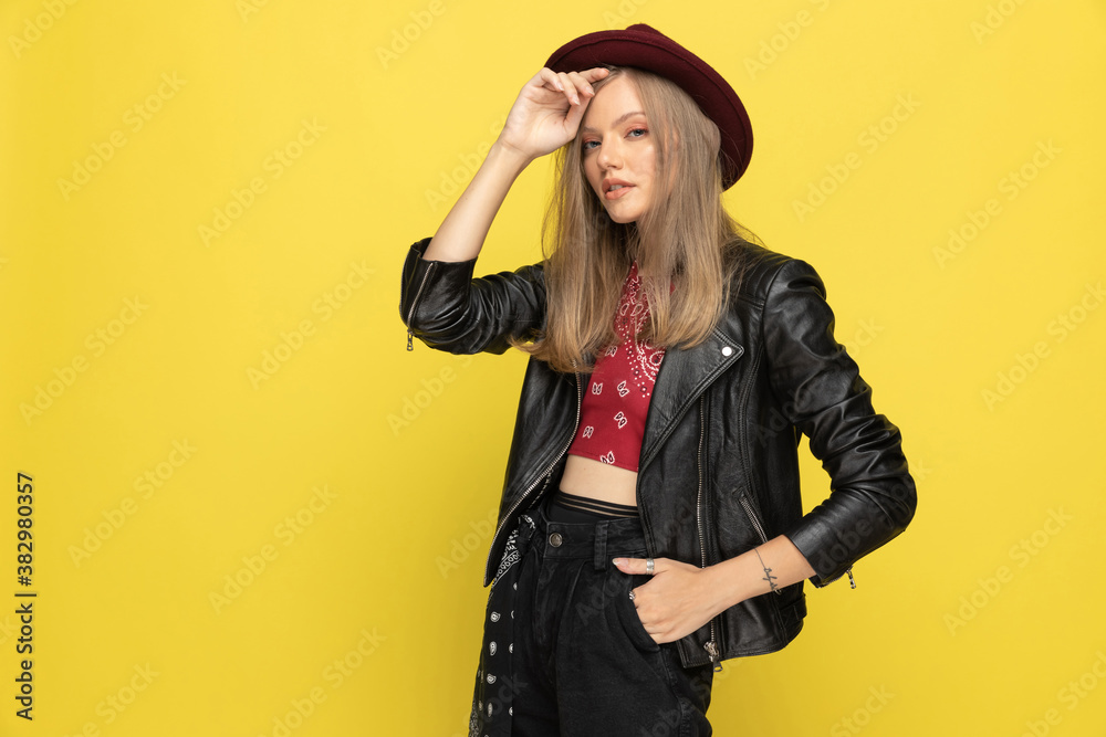 Charming fashion model fixing her hat, holding hand in pocket