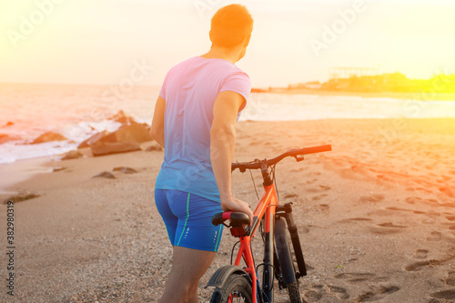 Unrecognizable man with bicycle at the beach