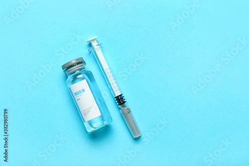 Bottle of insulin with syringe on color background. Diabetes concept