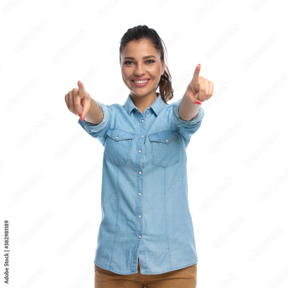 Happy smart casual woman pointing forward with both hands, smiling Happy smart casual woman pointing forward with both hands, smiling
