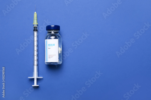 Bottle of insulin with syringe on color background. Diabetes concept photo
