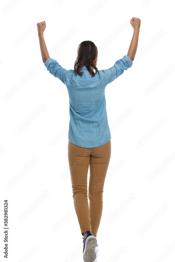 Back view of smart casual woman celebrating and walking Back view of smart casual woman celebrating and walking