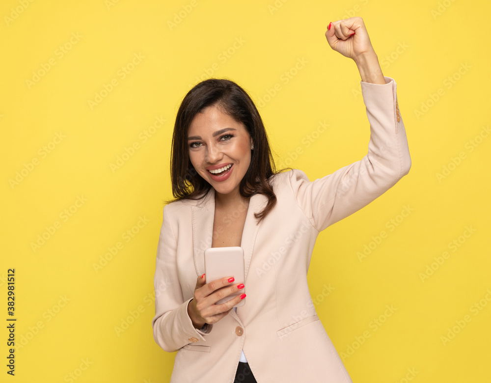 excited young businesswoman holding arm in the air excited young businesswoman holding arm in the air
