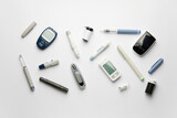 Glucometers with lancet pens and syringe on white background