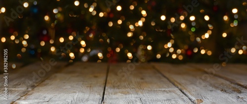 Christmas and New Year background banner with colorful bokeh lights and rustic wood
