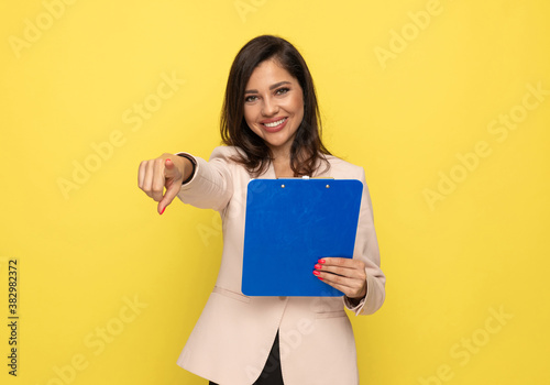 attractive woman in pink suit pointing finger and smiling